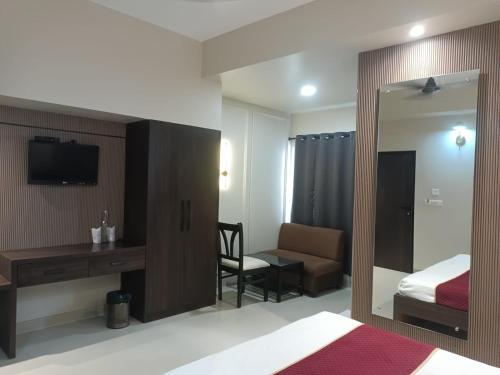 a bedroom with a bed and a desk and a mirror at SHELTER HOTEL in Lucknow