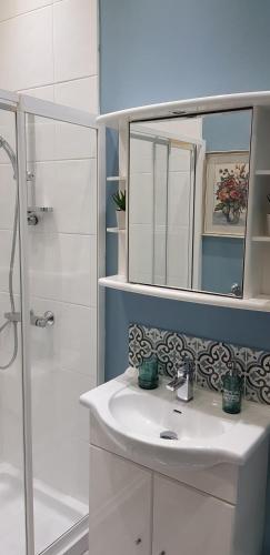 a bathroom with a sink and a shower and a mirror at Grange House Budget Rooms in Leeds