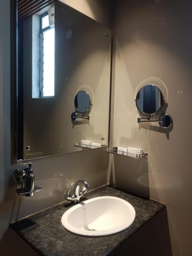 a bathroom with a sink and a mirror at SHELTER HOTEL in Lucknow