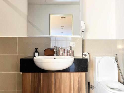 a bathroom with a white sink and a mirror at Bangsar Trade Centre By WeCare in Kuala Lumpur