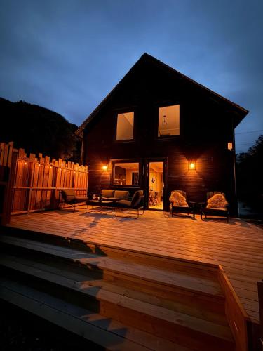 a house with a wooden deck at night at By the River in Vinje