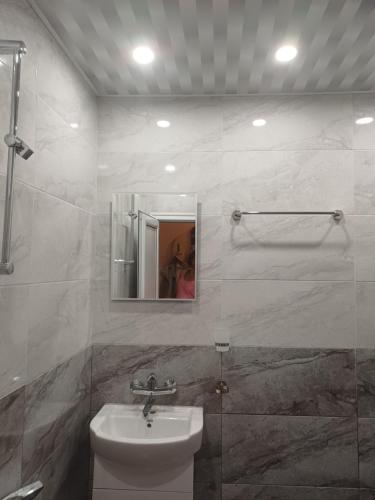 a bathroom with a sink and a toilet and a mirror at Апартаменти и стаи Анхиало in Pomorie