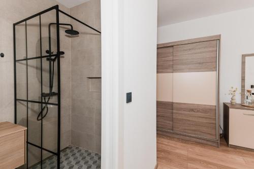 a shower with a glass door in a bathroom at Babin bed&breakfast in Pirovac
