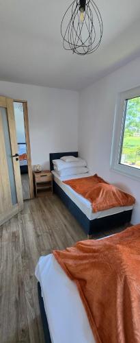 a bedroom with two beds and a chandelier at Kameralne Kładno in Łopienica