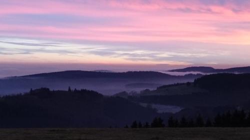 a view of a mountain range with a pink sky at Ferienwohnung Vier Pfoten in Willingen