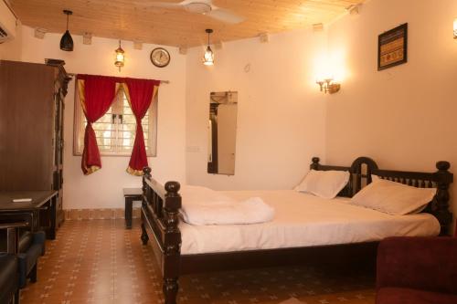 a bedroom with two beds and a desk and a window at The Royal Valley Resort in Chotila