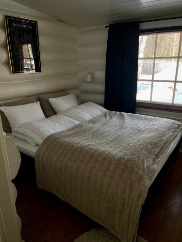 a large bed in a room with a window at Harju-Hill Villa in Rovaniemi