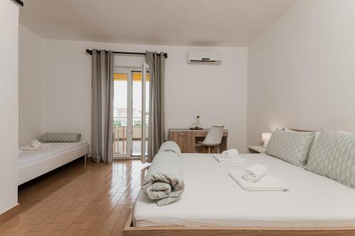 a white living room with a couch and a table at Babin bed&breakfast in Pirovac