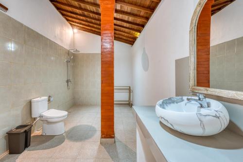 a bathroom with a sink and a toilet at Wigus Villa Melasti in Ungasan