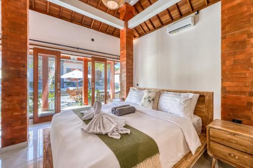 a bedroom with a bed with a towel on it at Wigus Villa Melasti in Ungasan