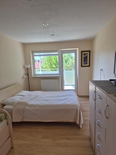a bedroom with a white bed and a window at Pas Rasą in Palanga