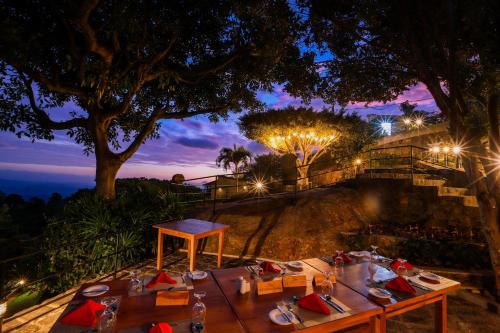 a table set up on top of a hill at night at Melheim Resort & Spa Haputale - An Infinite Escape into the Paradise in Haputale