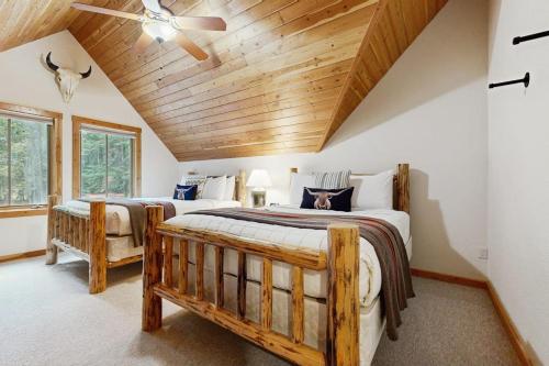 ein Schlafzimmer mit zwei Betten und einem Deckenventilator in der Unterkunft Deer Pine Cabin in Bigfork