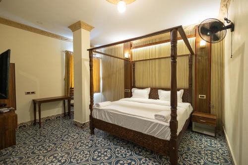 a bedroom with a canopy bed in a room at Krish Inn in Chidambaram