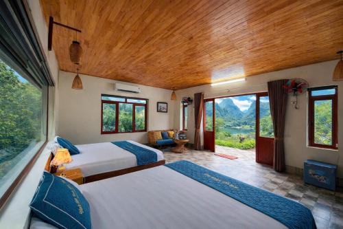 a bedroom with two beds and a large window at Chinh Thu Garden Homestay in Ninh Binh