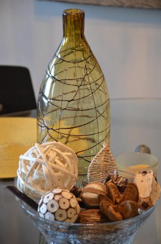 a glass bowl filled with shells and a glass vase at Monki Di Executive Suites - Alura in Calgary