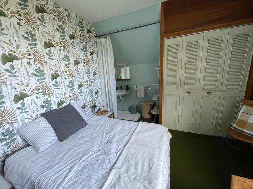 a bedroom with a white bed and a bathroom at Chambre à louer face a la plage de Beaumer in Carnac
