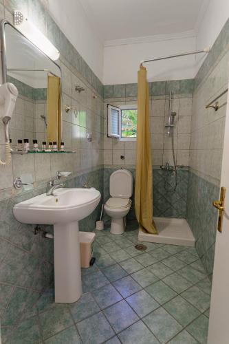 a bathroom with a sink and a toilet and a shower at Empress Corfu in Perama