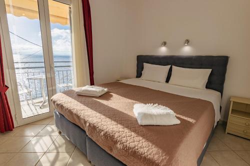 a bedroom with a bed with a view of the ocean at Empress Corfu in Perama
