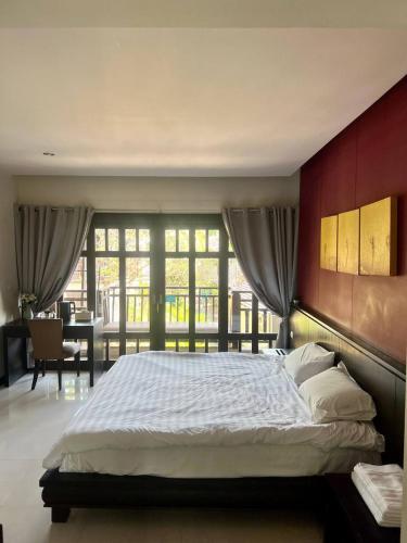 a bedroom with a large bed with a red wall at Sea view apartments in Nathon Bay
