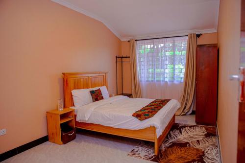 a bedroom with a bed and a window at Kiliheights Getaway in Sanya Chini Station