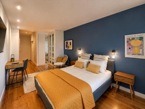 a bedroom with a large bed with a blue wall at BlueCap by MyTrip Porto in Matosinhos