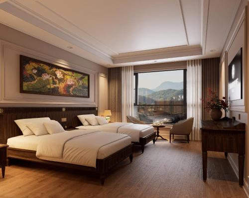 a bedroom with two beds and a large window at Dalabiang Hotel in Da Lat