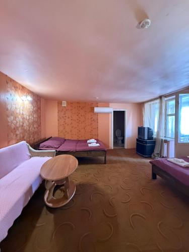 a room with two beds and a table in it at Стара Прага in Uzhhorod