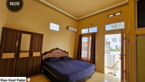 a bedroom with a bed in the corner of a room at Rian Kost - Hotel Penginapan Murah Pusat Kota Palembang in Palembang