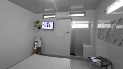 a hospital room with a bed and a tv on the wall at Rian Kost - Hotel Penginapan Murah Pusat Kota Palembang in Palembang