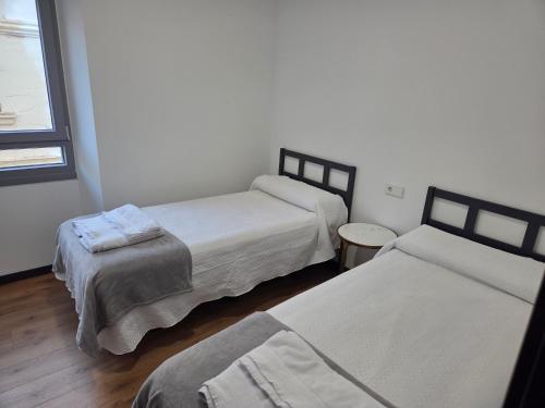 a bedroom with two beds and a window at Pasaje Plaza Apartamento in Alcazar de San Juan