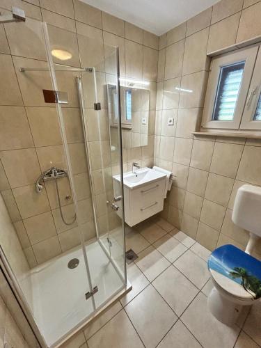 a bathroom with a shower and a toilet and a sink at Apartment Smuljic in Vrboska