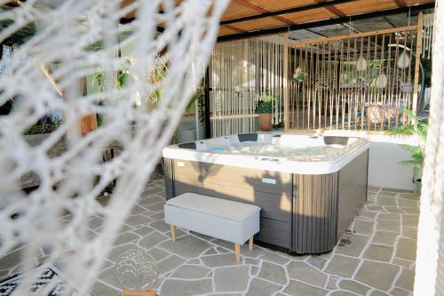 a jacuzzi tub sitting on a patio with a bench at Thassion-ikea Feels Like Home in Astris