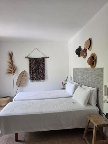 a bedroom with a large white bed with white pillows at Casa Naya Ibiza in Sant Llorenç de Balafia