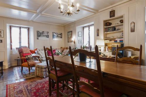 a dining room and living room with a table and chairs at Appartement ambiance vieux chalet in Sembrancher