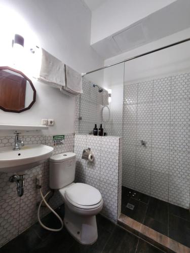 a bathroom with a toilet and a sink and a shower at Domore Lifestyle in Yogyakarta