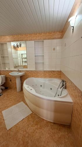 a large bathroom with a tub and a sink at Стара Прага in Uzhhorod