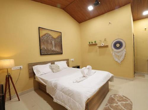 a bedroom with a large bed with white sheets at Veranda hillside retreat in Kharakvasla