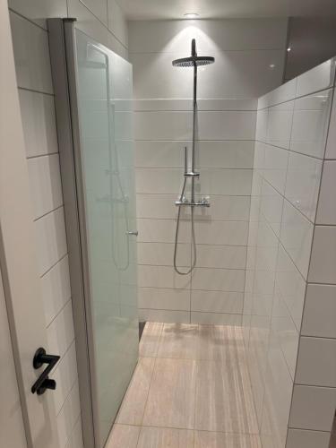 a bathroom with a shower with a cross on the wall at Leilighet på RyenToppen med gapahuk in Kristiansand