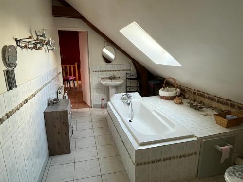 a bathroom with a large tub and a sink at Le champ de l alouette in Bec-de-Mortagne