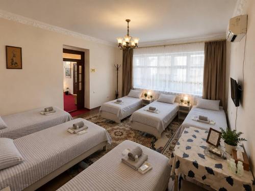 a living room with three beds and a couch at SAM GREEN HOUSE Hostel in Samarkand