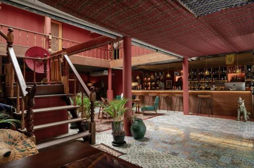 a bar with red walls and stairs in a room at Ḥokma Boutique Hotel & Tropical Lounge in Phi Phi Islands
