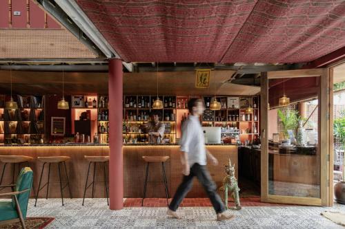 a man walking in front of a bar at Ḥokma Boutique Hotel & Tropical Lounge in Phi Phi Islands