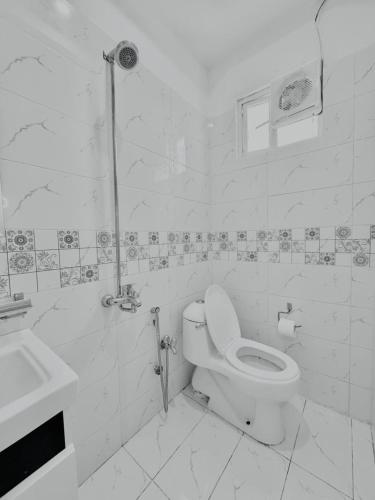 a white bathroom with a toilet and a sink at Gulberg Greens Islamabad in Islamabad