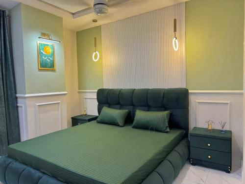 a bedroom with a large green bed with two pillows at Gulberg Greens Islamabad in Islamabad