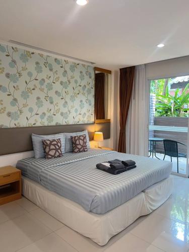 ein Schlafzimmer mit einem großen Bett und einer Wand in der Unterkunft Windmill Resort Hotel Pattaya in Pattaya North
