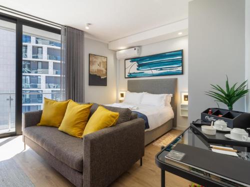 a living room with a couch and a bed at Lux @ Ellipse Galelileo in Midrand