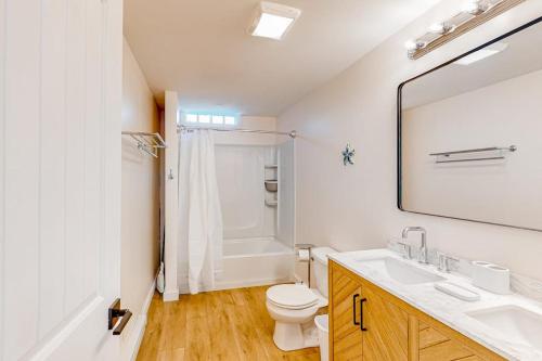 a bathroom with a sink and a toilet and a mirror at Shorebreeze Inn in Kennebunk
