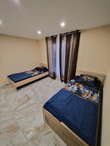 two beds in a room with marble floors at Maison de Luxe Entière in Chalon-sur-Saône
