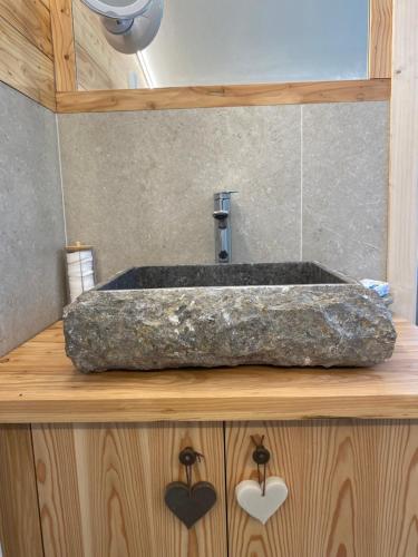 a bathroom with a stone sink with a faucet at Xenìa in Villalago